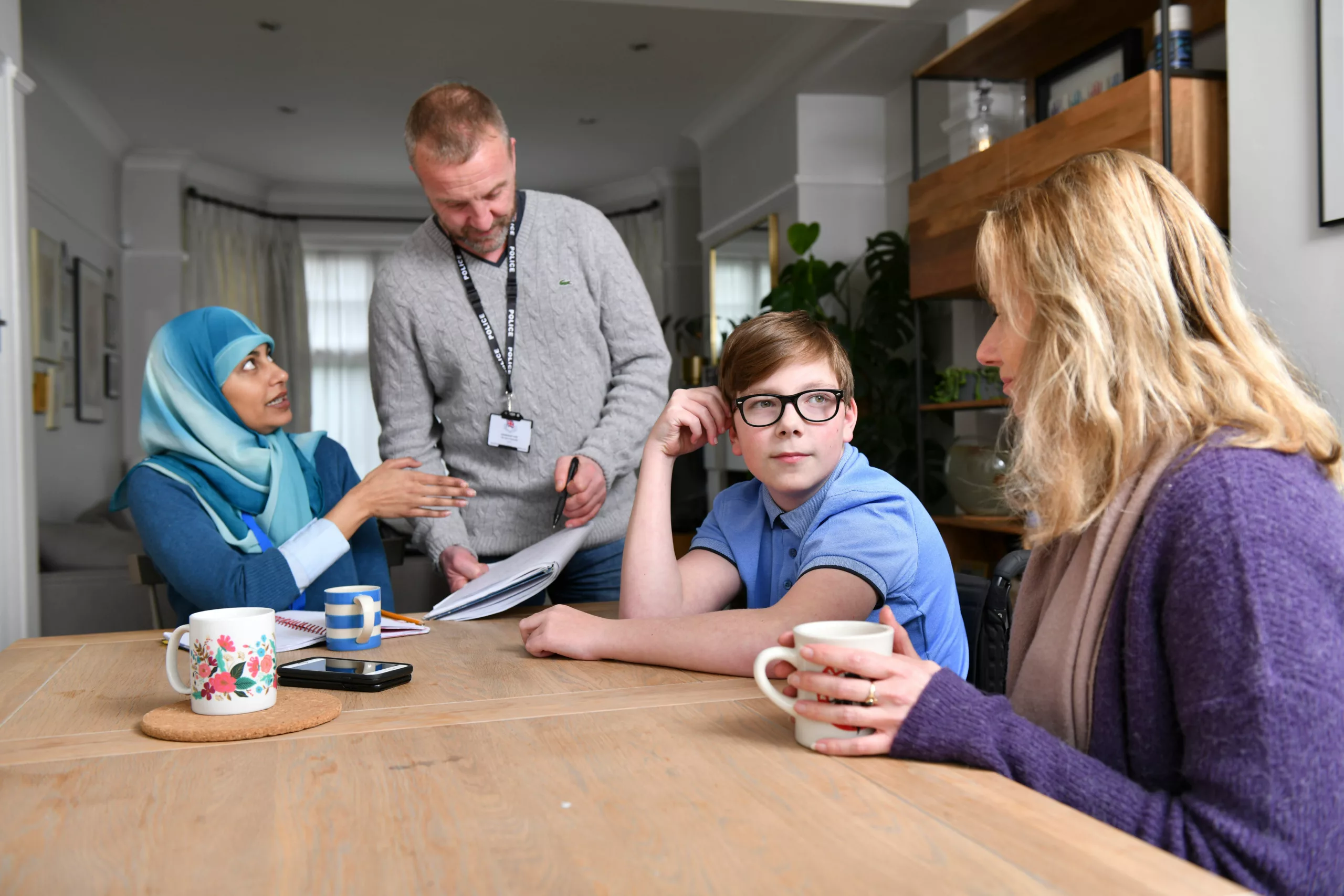 Child with family and professionals sat around a kitchen table