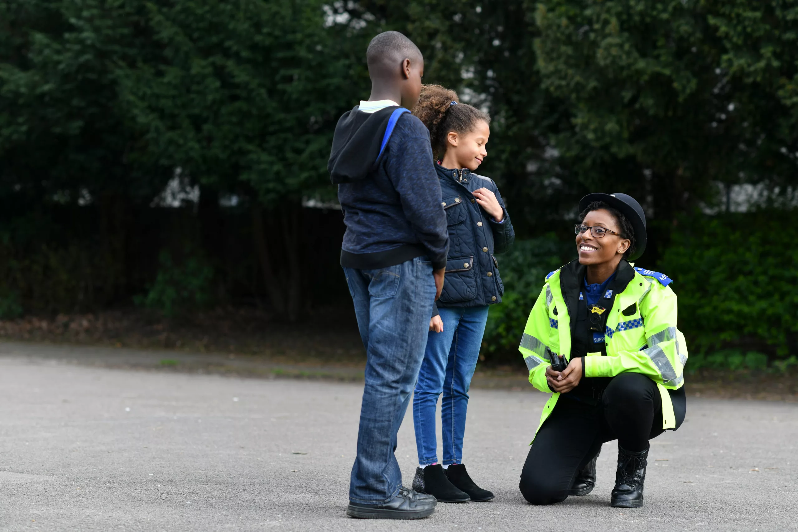 Police officer speaking to two children in a park