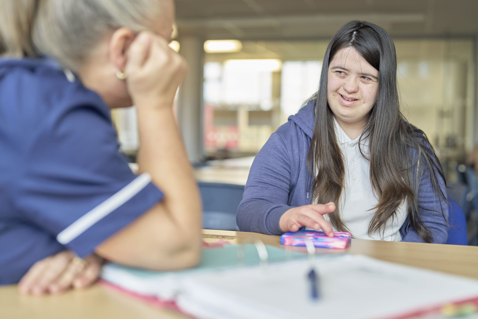 Nurse chatting to a young woman who is smiling