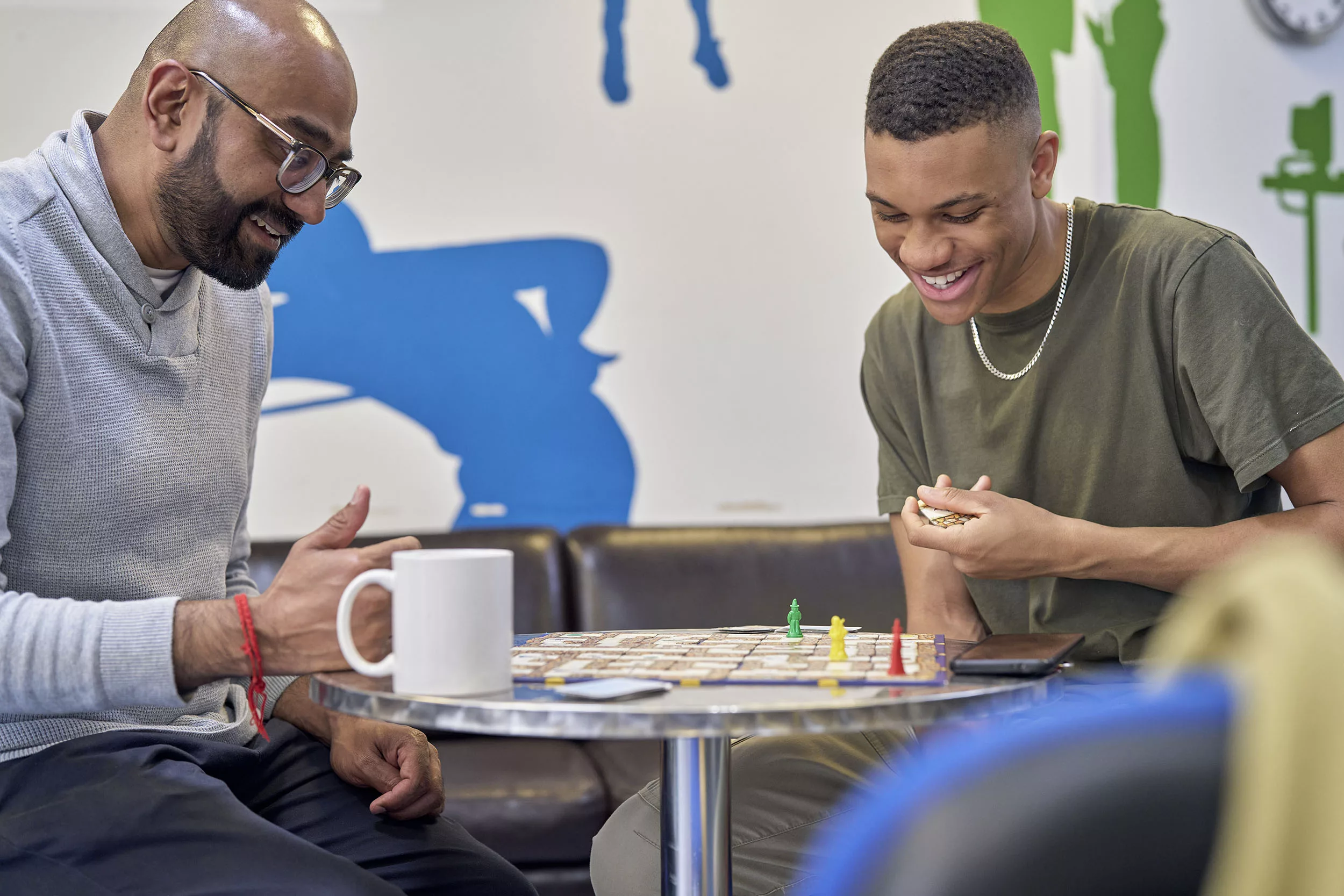 Professional playing a board game with a teenager in a youth club