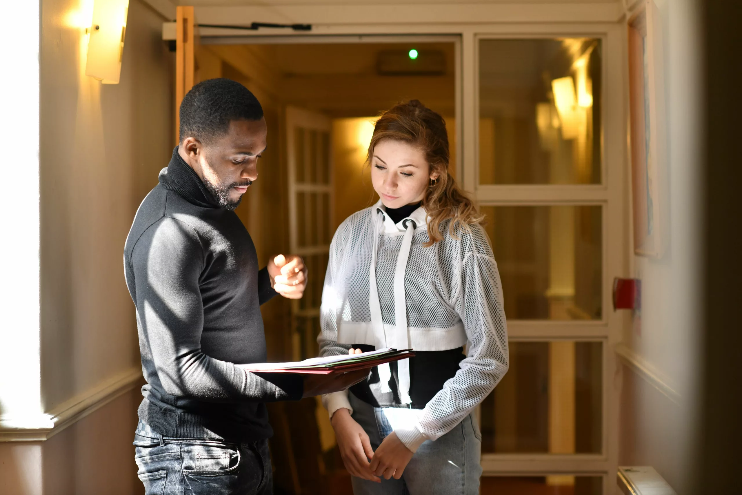 Professional stood with young person in corridor