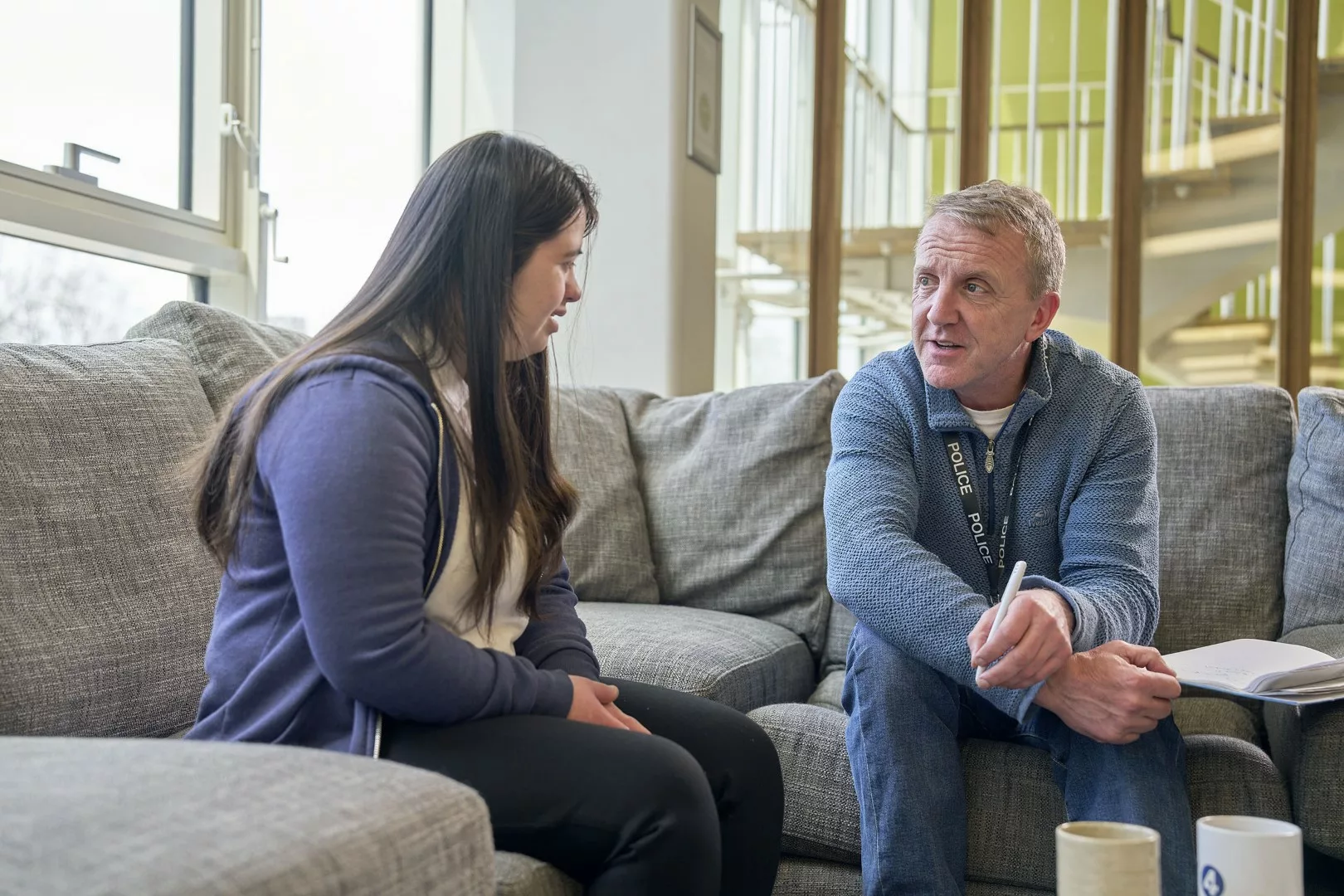 Policeman in plain clothes talks to young woman with a disability