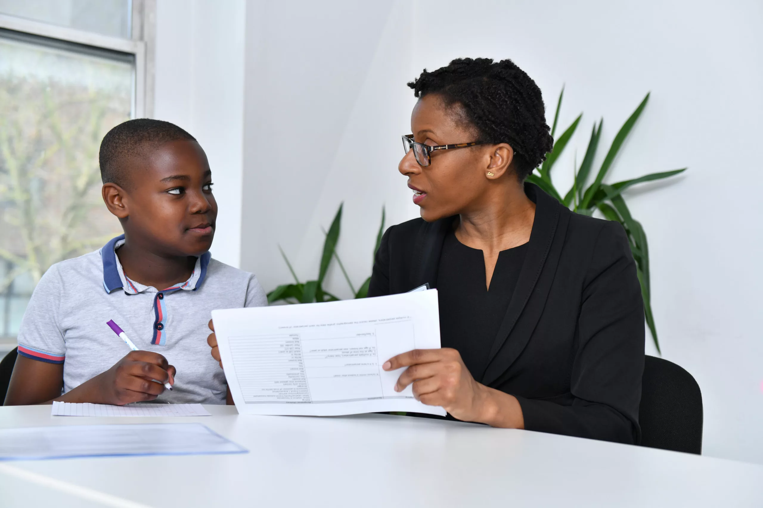 Professional and child looking at a document in an office