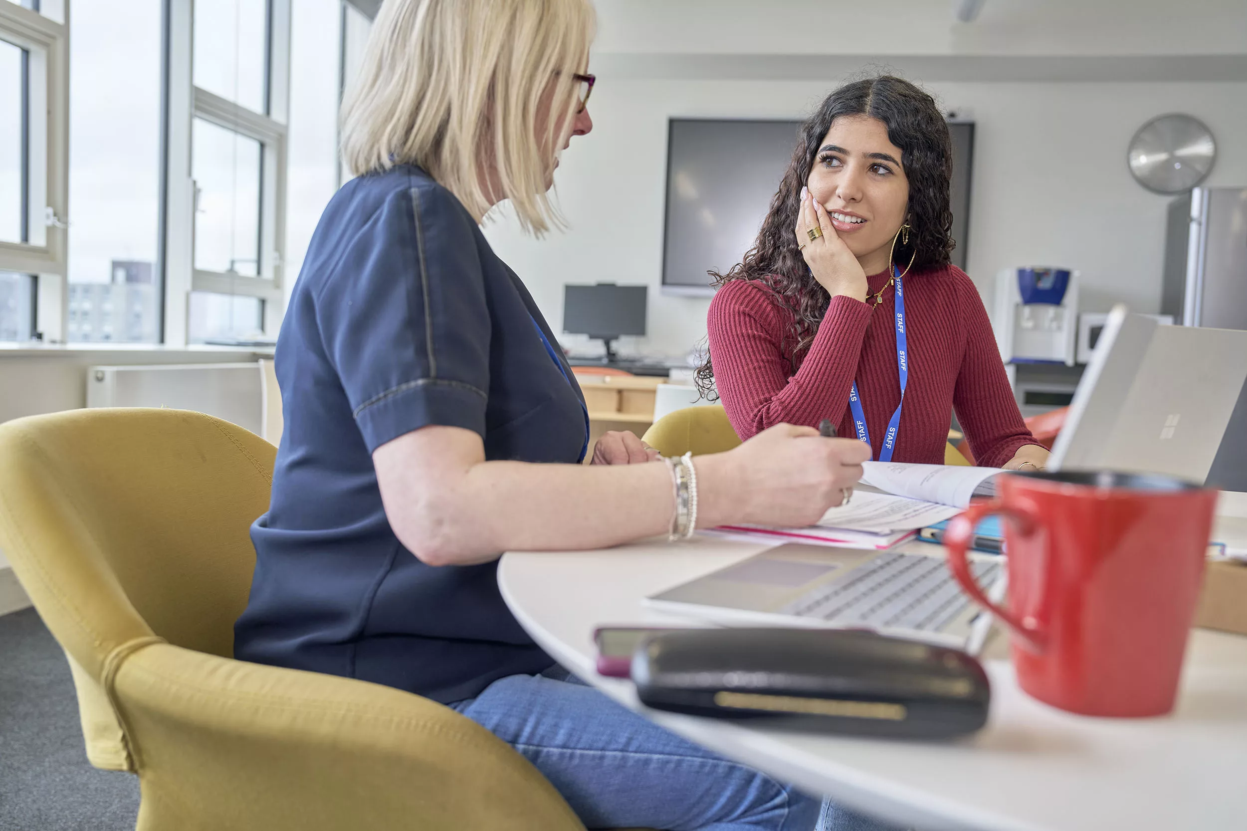 Social worker talking to their supervisor at a desk