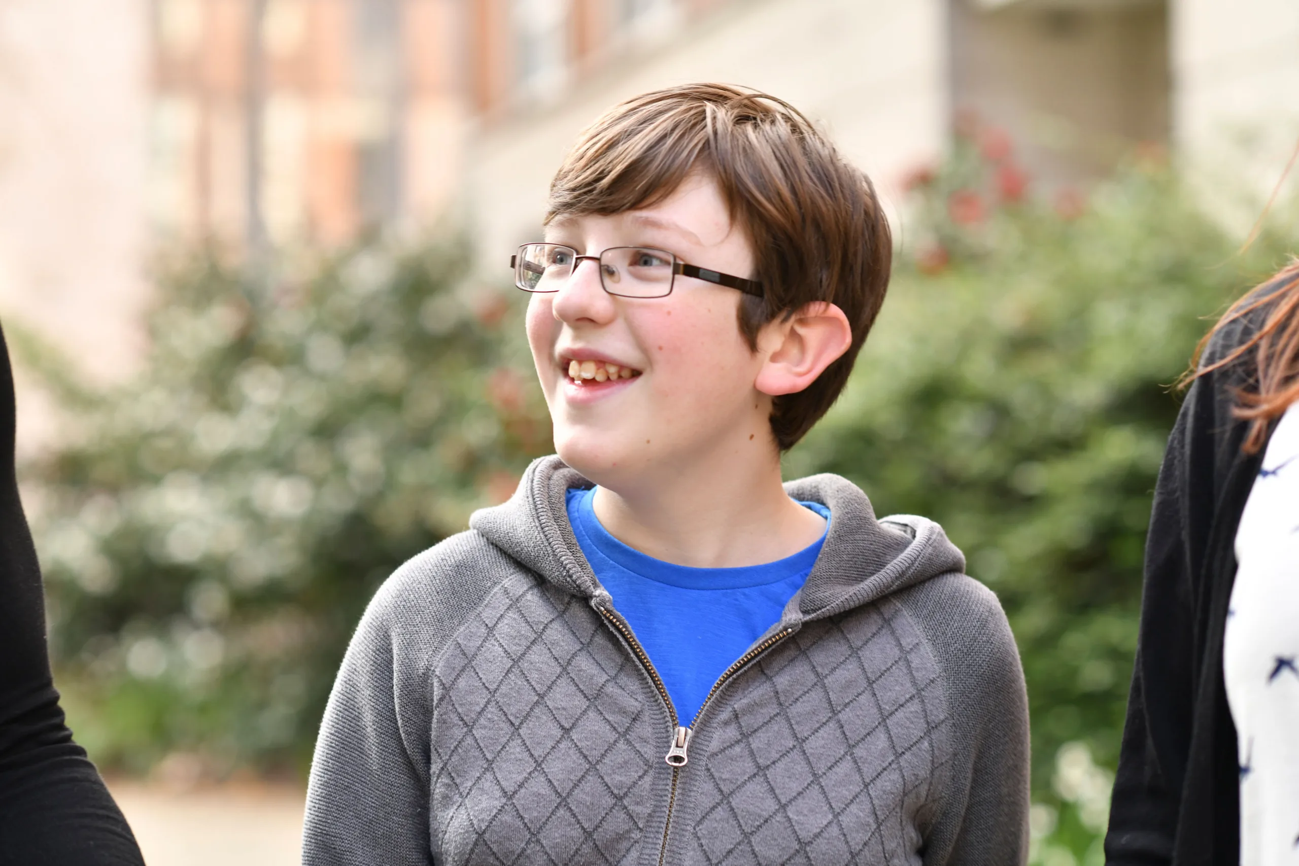 Boy around the age of 11 smiling and looking to his right