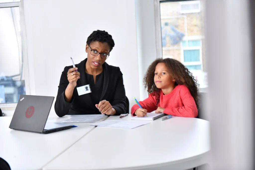 Female professional speaking to a girl in a bright office room